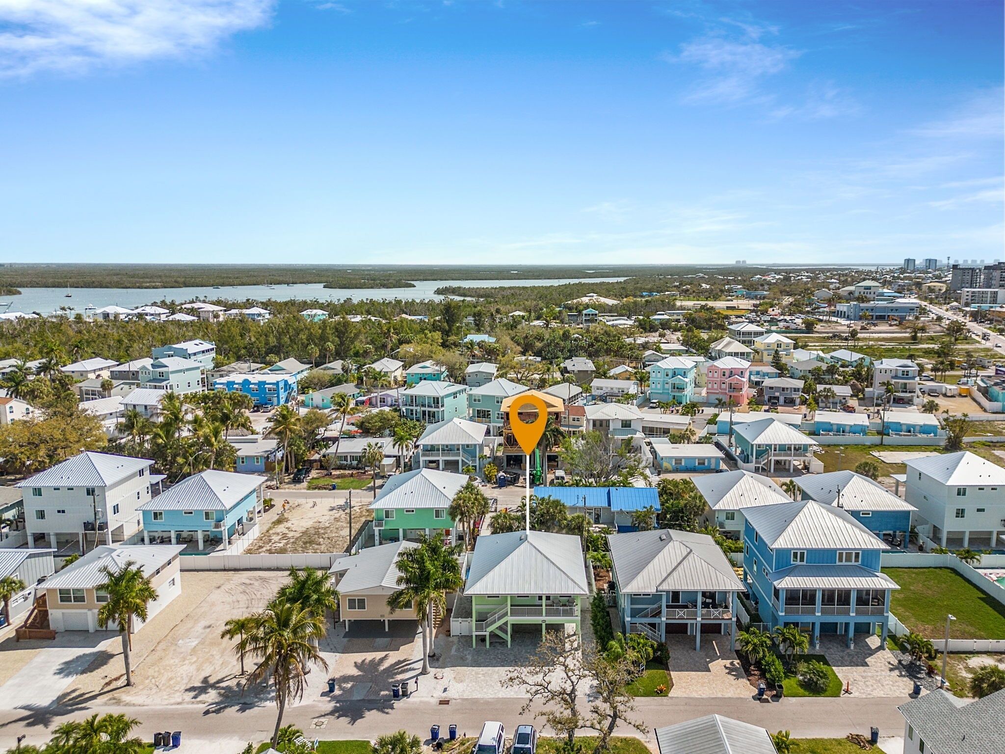 A coastal residential area with houses, a beach, and a body of water.