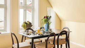 A dining area with a table, chairs, and hanging pendant lights.