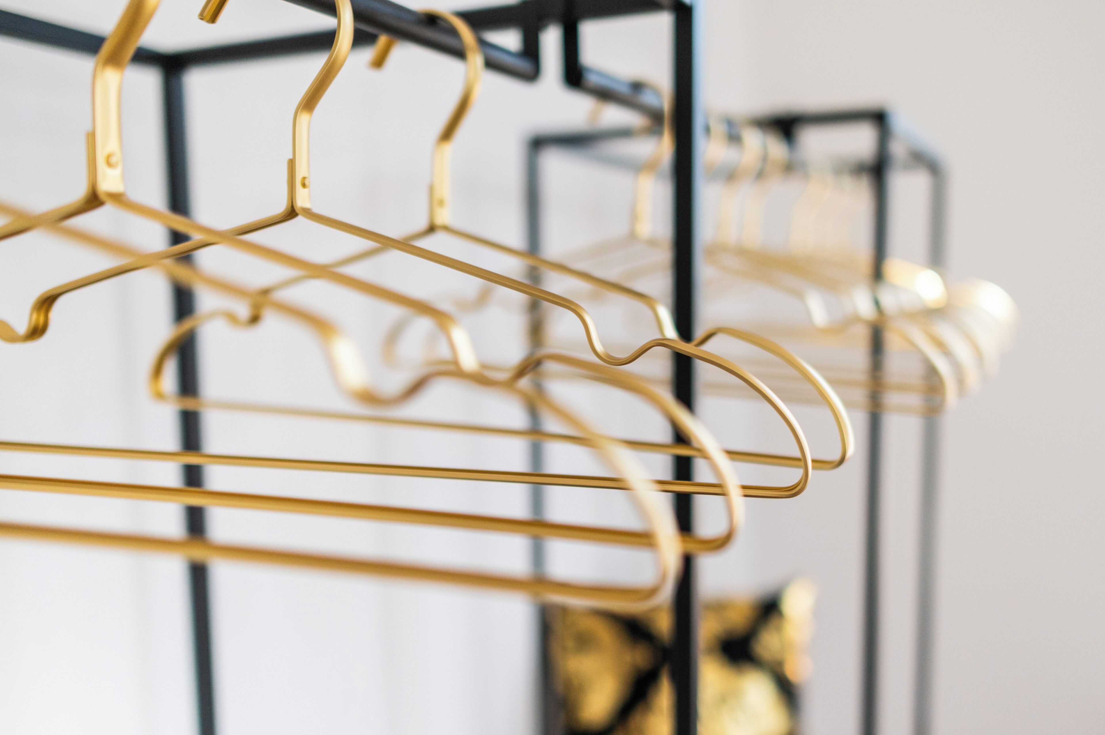 A close-up of a gold-colored metal hanger rack.