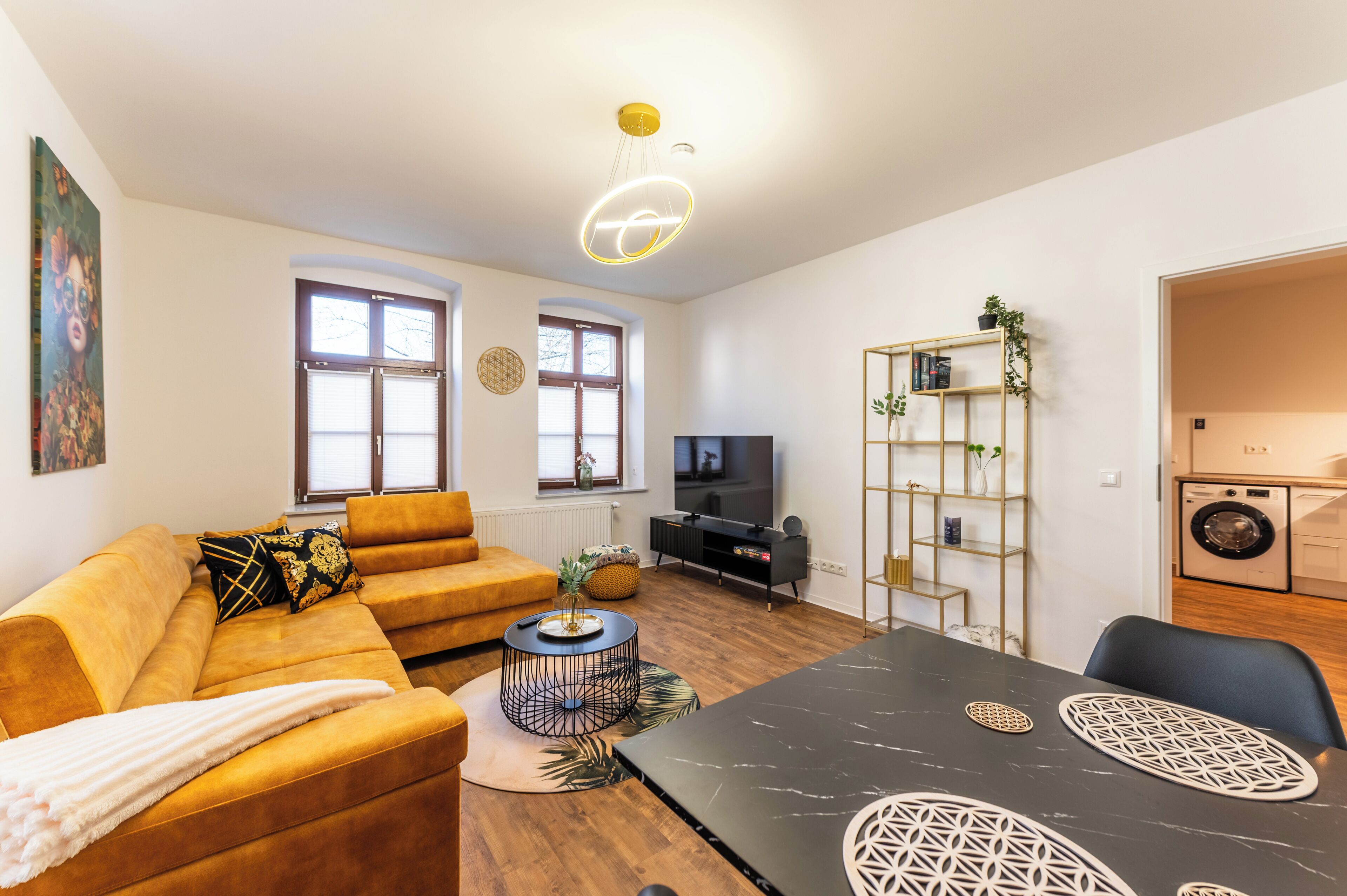 Ein Wohnzimmer mit einer Couch, einem Couchtisch, einem Fernseher und einem Essbereich.