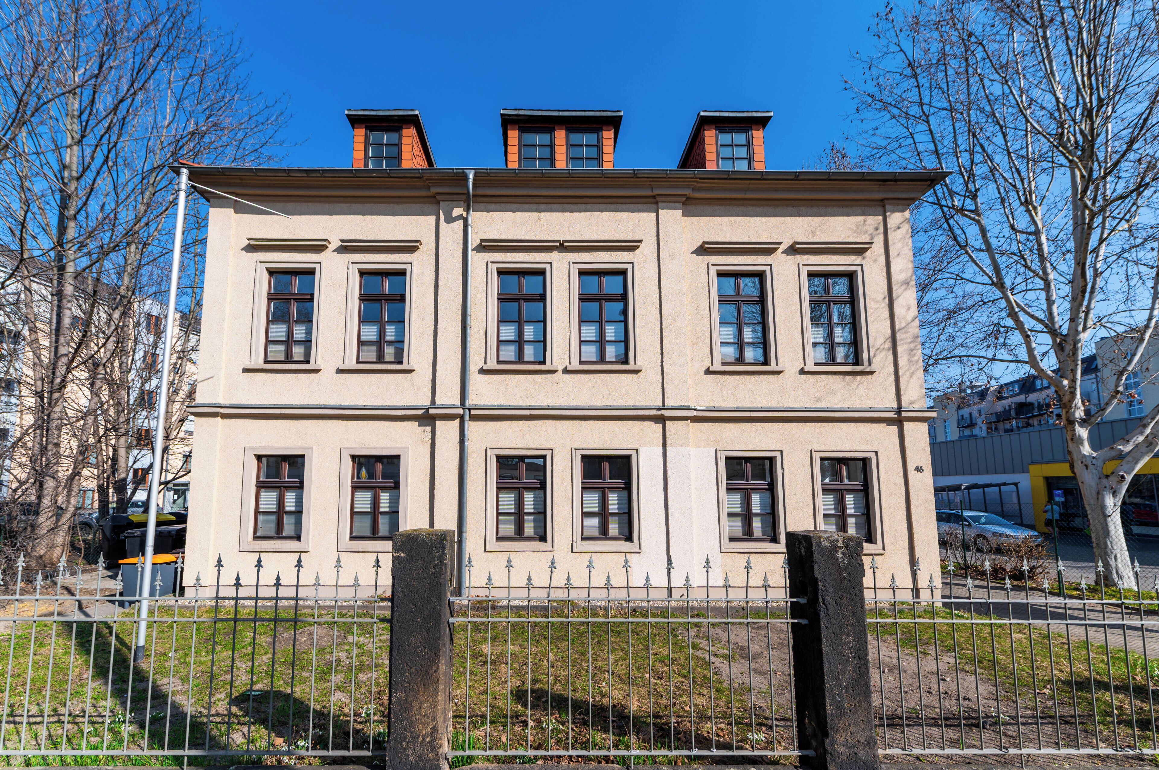 A multi-story building with a symmetrical facade, evenly spaced windows, and a central entrance.