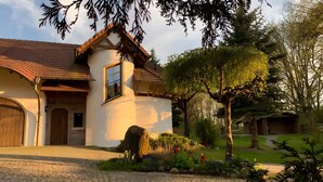 A house with a sloped roof, a wooden door, and a garage. - Nature-Inspired 100 m² Apartment with Fenced Garden, Terrace & Wi-Fi – Dog-Friendly (Neuzelle)
