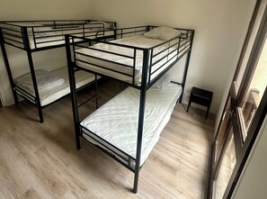 A room with bunk beds, wooden flooring, and a small stool. - Private estate for 35 people • Lake Rillé (37) • Nature, Space, Sharing (Rillé)