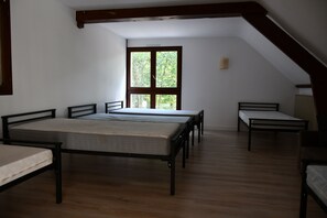 Une chambre avec deux lits, une fenêtre et un plafond en pente.