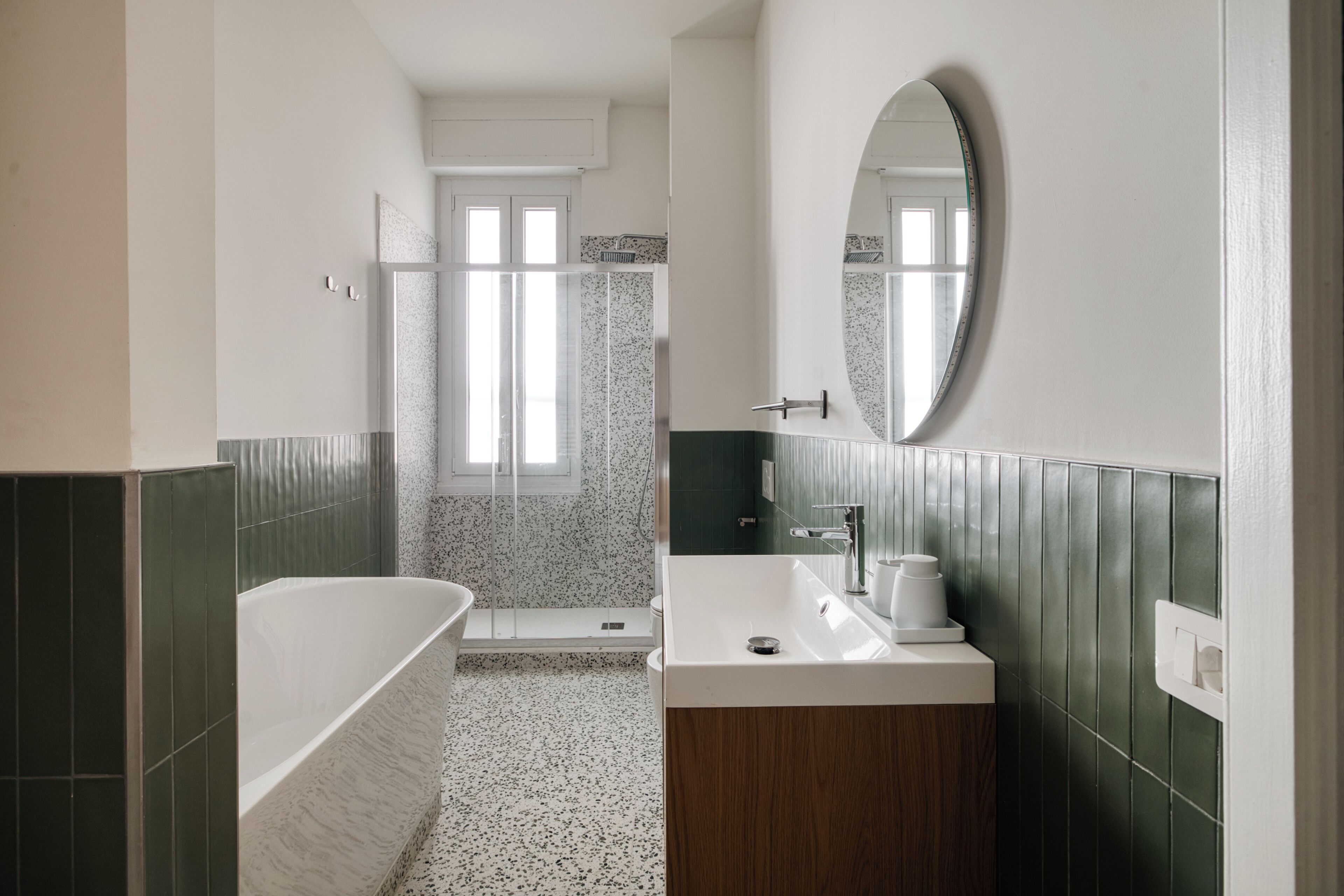 Une salle de bain moderne avec une baignoire sur pieds, un lavabo avec un miroir et un espace douche.