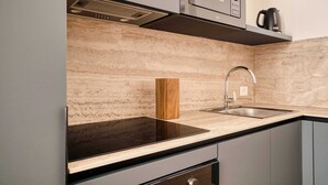 Een moderne keuken met een zwart aanrecht, een roestvrijstalen spoelbak en een ingebouwde magnetron.