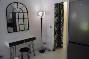 A modern kitchen with a white countertop, a black-framed mirror, a floor lamp, and a refrigerator. - Studio "Cap D’Antibes" with Wi-Fi and Air Conditioning (Antibes)