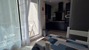 A modern kitchen with dark cabinets, a microwave, and a coffee maker. - Beautiful, bright, renovated apartment in the center of Concarneau with private parking (Concarneau)