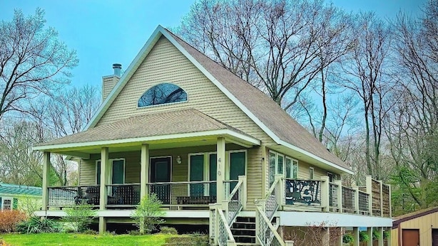 A two-story house with a porch, a covered front porch area, and a staircase leading to the second floor.