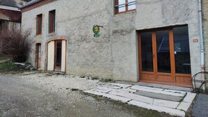 Un bâtiment avec une façade en pierre, une porte en bois, une fenêtre et une enseigne indiquant qu’il s’agit d’un « gîte de groupe ».