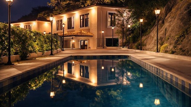 A swimming pool with a house in the background.