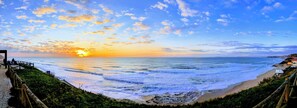 A coastal view with a wooden walkway, beach, and ocean. - Silver Coast Retreat - Luxury apartment on the Beach in Praia da Areia Branca PT (Lourinhã)