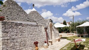 Un bâtiment en pierre avec des toits coniques, des tables à l’extérieur et des parasols.