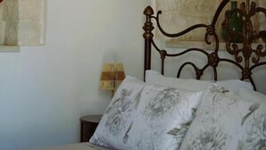 Une chambre à coucher avec un lit, une table de chevet et une lampe.