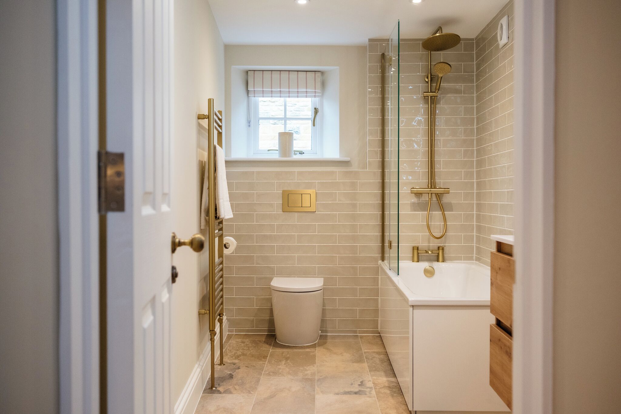A bathroom with a toilet, a window, a shower, and a bathtub.