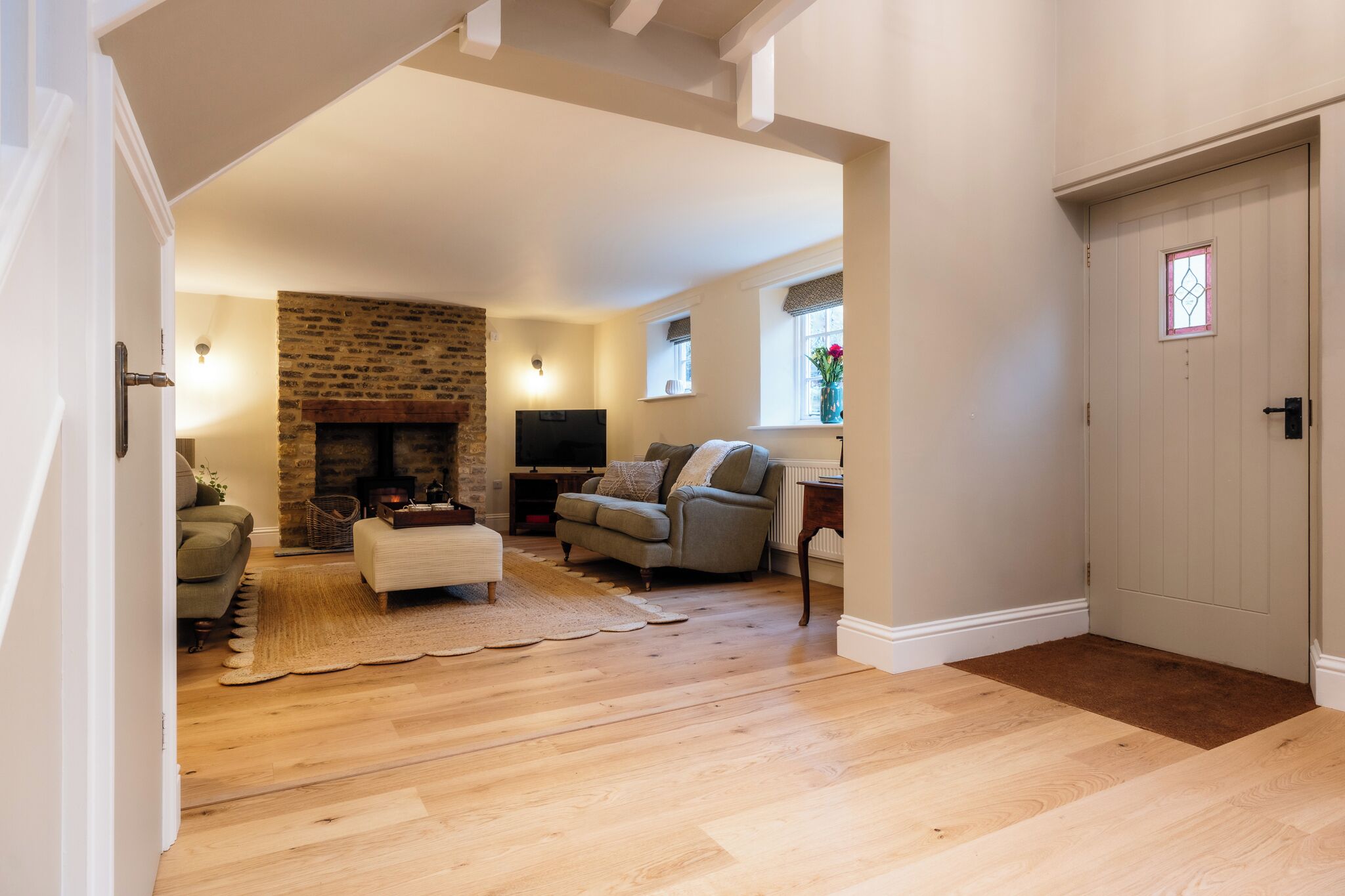 A living room with a fireplace, a sofa, a television, and a wooden floor.