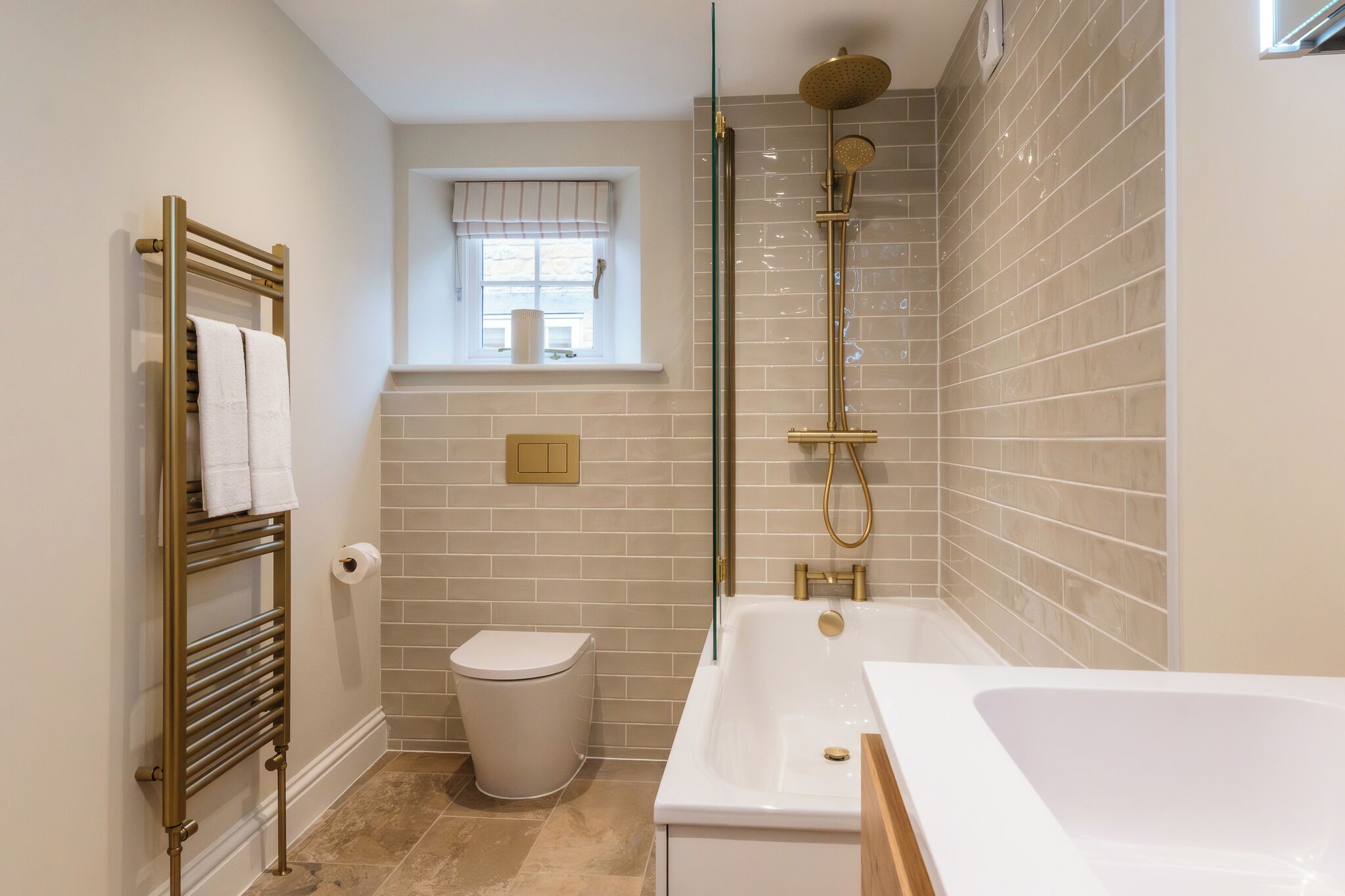 A modern bathroom with a bathtub, toilet, and shower.