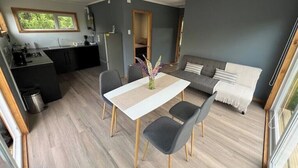 Eine moderne Küche mit Essbereich, einer Couch und Blick ins Freie.