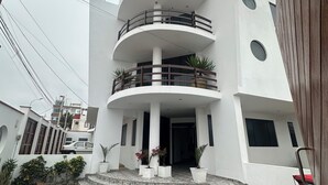 Un edificio a più piani con un cortile centrale, balconi e piante in vaso.