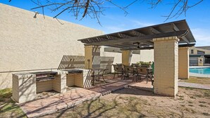 An outdoor barbecue area with a grill, chairs, and a covered seating area. - Eden's Escape Comfort, Style & Prime Phoenix Location (Phoenix)