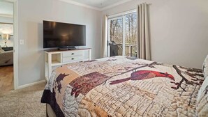 A bedroom with a bed, a TV on a stand, a ceiling fan, and a window with curtains. - NEWLY RENOVATED COZY 2BR 1BA COTTAGE -NEW HOT TUB (Sautee Nacoochee)