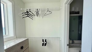Une salle de bain avec une douche, un miroir et un porte-serviettes.