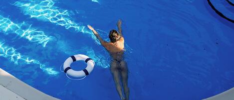 A person swimming in a pool with a lifebuoy.