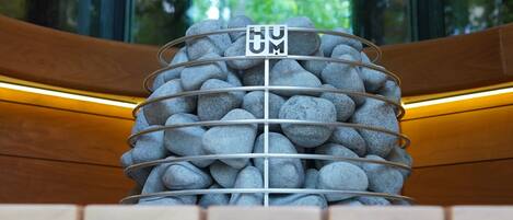 Pared de piedra con un letrero que dice 'HUM' en un edificio moderno.