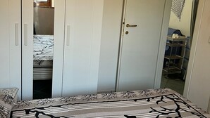 Una camera da letto con un letto, un armadio e una porta che dà su un bagno.