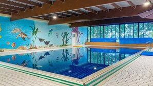 An indoor swimming pool with a mural of sea life, a clear view of the outdoors, and a tiled floor. - Beautiful Cottage for 6 in Ewijk Park (Ewijk)