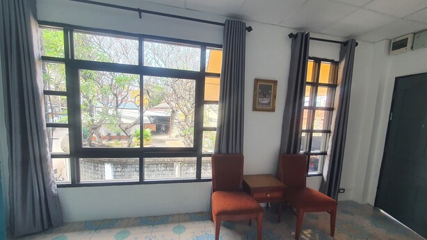A room with a large window, two chairs, a small table, and a bed. - Room-charming Boutique Guest Retreat in (Chiang Mai)