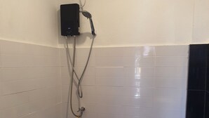 A small bathroom with a toilet, a bidet, and a shower head mounted on the wall. - Room-charming Boutique Guest Retreat in (Chiang Mai)