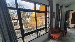 A room with a large window, a chair, and a tiled floor. - Room-charming Boutique Guest Retreat in (Chiang Mai)