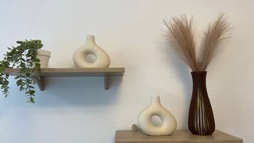 A minimalist decor setup with two wall-mounted shelves holding vases and a potted plant.