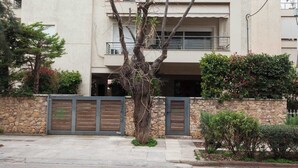 A multi-story residential building with balconies, air conditioning units, and a stone wall with a gate. - Bright Minimal 2 Bd Apt in Marousi (Marousi)
