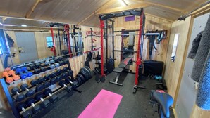 A gym with weightlifting equipment, a bench, and a mirror. - Beautiful cottage located just steps from the main beach (Sauble Beach)