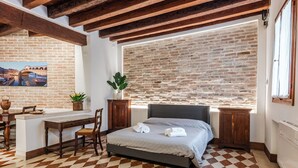 Ein Schlafzimmer mit kariertem Boden, einem Bett, einem Schreibtisch und einem Fenster mit Blick.