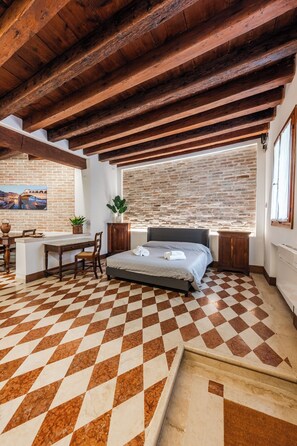 A bedroom with a checkered floor, a bed, a desk, and a window with a view. - GDL HOUSE VENICE (Venezia)