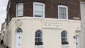 A two-story building with a sign for 'The Three Compasses Restaurant & Free House.' - New beach front sea view apartment superking or twin. Featured in Netflix series (Deal)