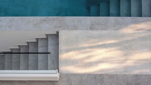 Eine Treppe mit Glasgeländer, die zu einer höheren Ebene führt.