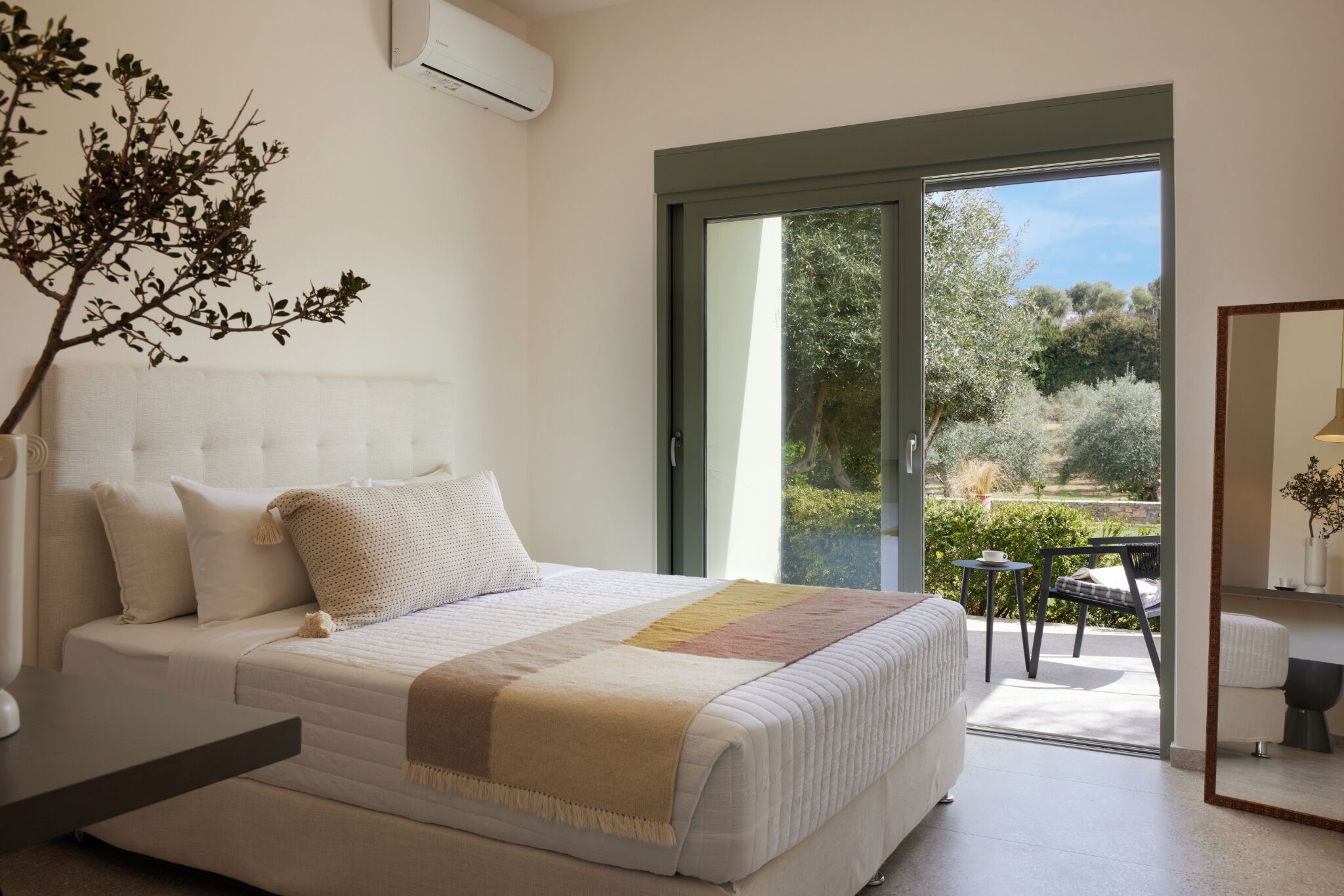 Un dormitorio con cama, mesita de noche y vistas al exterior.