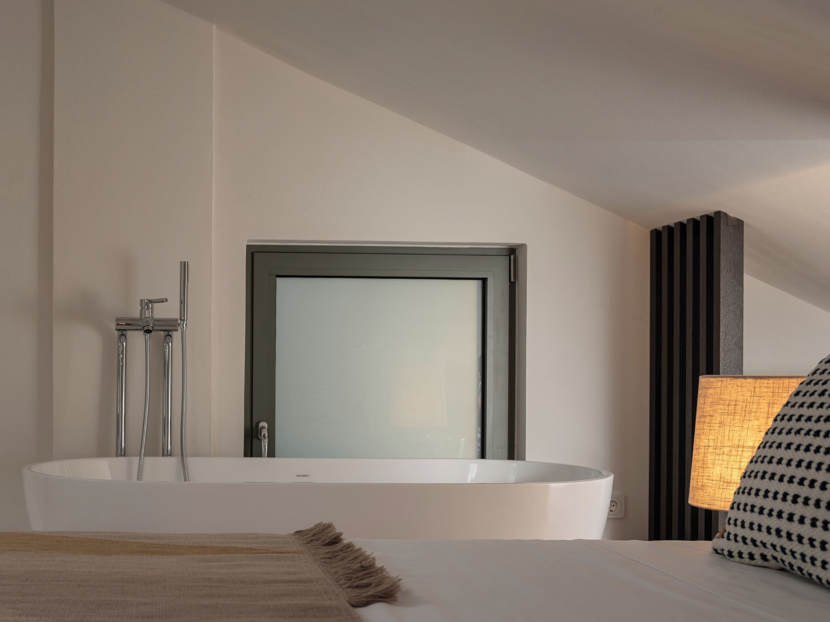 A modern bathroom with a freestanding bathtub, a towel rack, and a mirror.