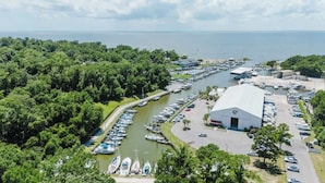 A marina with boats docked, a large white building, and surrounding greenery. - Fly Creek Collection - Sunset Perch (Fairhope)