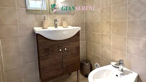 Un baño con tocador, lavabo, espejo y paredes de azulejos.
