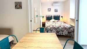 Un dormitorio con cama, mesita de noche y una silla.