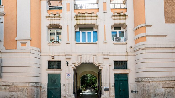 Un bâtiment doté d’une arche centrale, de portes vertes et d’un panneau indiquant qu’il est interdit de se garer.