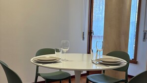 A dining area with a round table, four chairs, and two wine glasses.