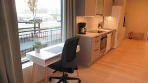 Een moderne keuken met een eethoek, een koffieapparaat en uitzicht op de straat.