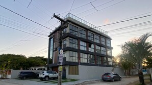 Um edifício de vários andares com design arquitetônico moderno, caracterizado por grandes janelas e um telhado plano.