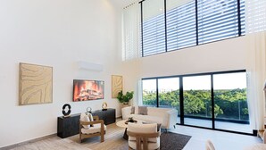 Un salon moderne avec une cheminée, un canapé, une table basse et un coin repas avec une table mise pour deux personnes.